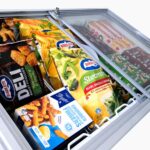 Image of the inside of a 296L small white display chest freezer with colourful frozen goods inside.