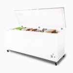 Image of a 675L large white chest freezer with a stainless steel top, right angled view with frozen goods inside.