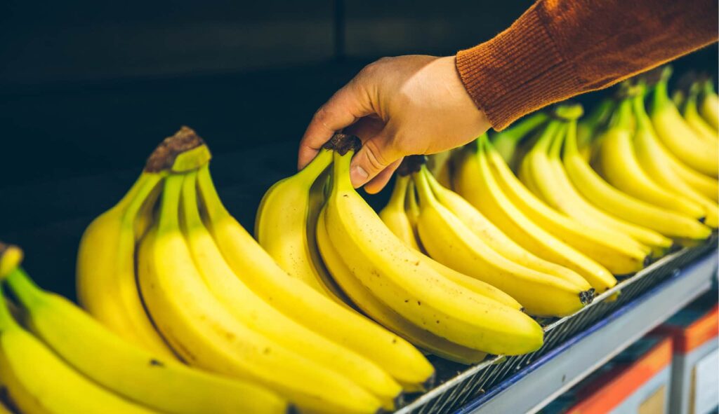 Image of a person about to grab a bunch of bananas.