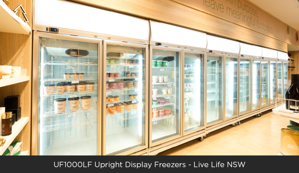An image of six Bromic UF1000LF upright display freezers in Live Life organic grocery store.