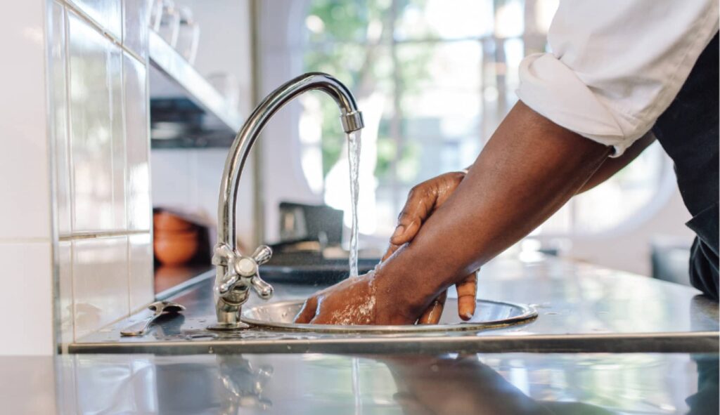 An image of a person washing their hands in the sink.